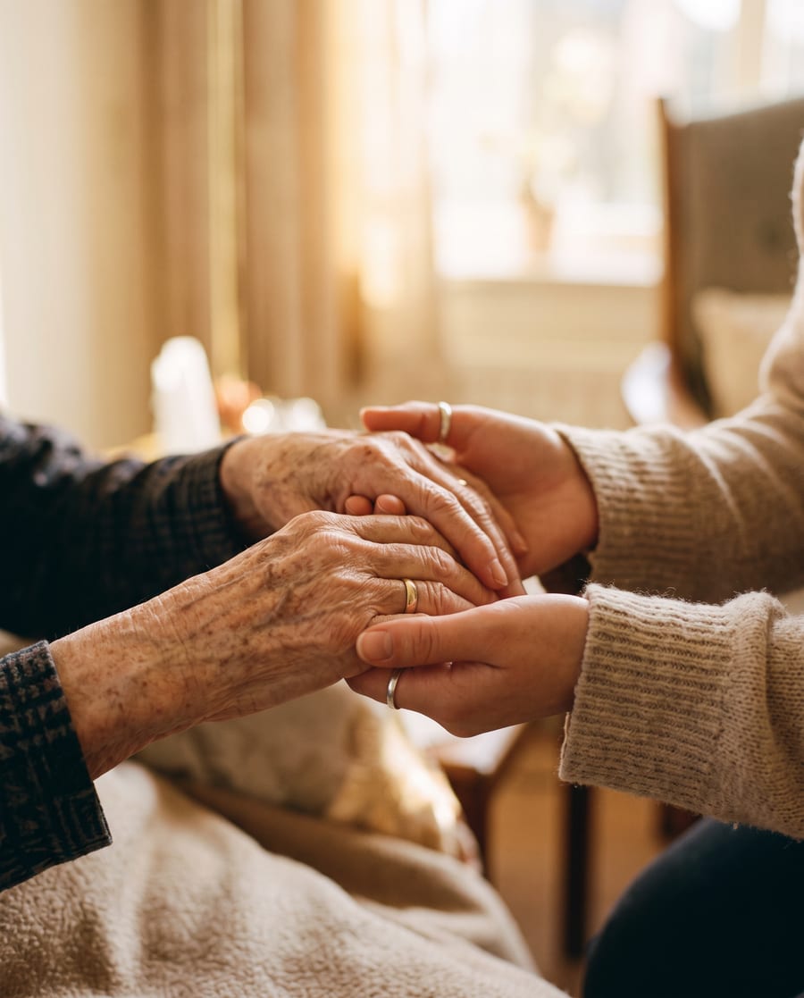 A caregiver holding a senior's hands with care